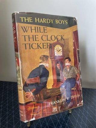 Item #93880 While the Clock Ticked (The Hardy Boys). Franklin W. Dixon